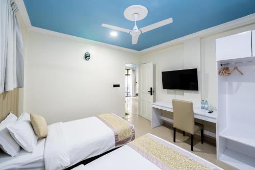 a bedroom with a bed and a desk and a television at Air Residence 10978 in Hulhumale