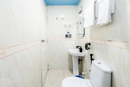 a white bathroom with a toilet and a sink at Air Residence 10978 in Hulhumale