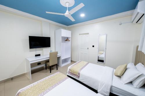 a bedroom with a bed and a desk with a television at Air Residence 10978 in Hulhumale