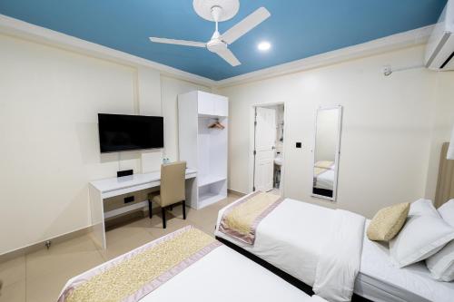 a bedroom with a bed and a desk with a television at Air Residence 10978 in Hulhumale