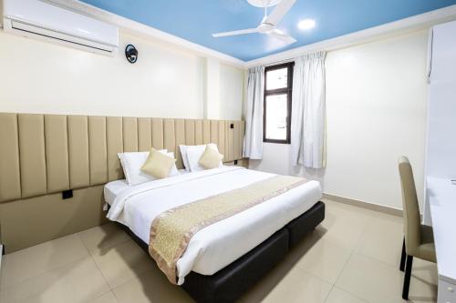 a bedroom with a large bed with a blue ceiling at Air Residence 10978 in Hulhumale