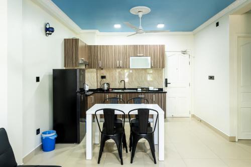 a kitchen with a white table and black chairs at Air Residence 10978 in Hulhumale