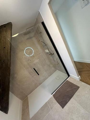 une douche avec une porte vitrée dans une salle de bain dans l'établissement maison LE 3 haut de gamme centre historique, à Quimperlé