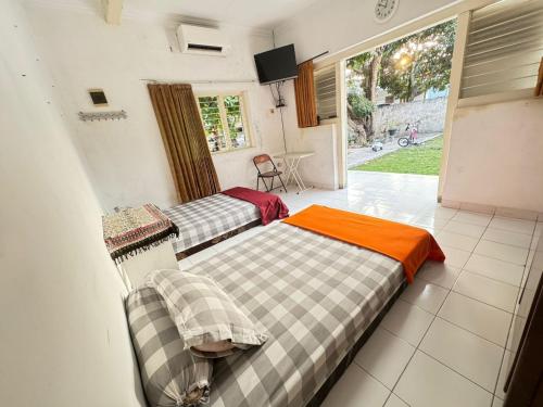 two beds sitting in a room with a window at Omah Sinduadi Homestay Jogja in Kejayan