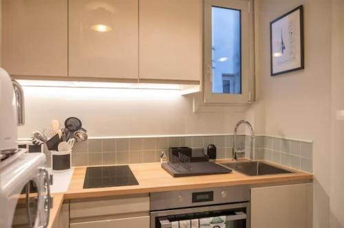une cuisine avec un évier et un plan de travail dans l'établissement Villa Montparnasse - 15th arr, à Paris