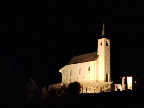 a white church with a steeple at night at Appartement Bergliebe in Mauterndorf