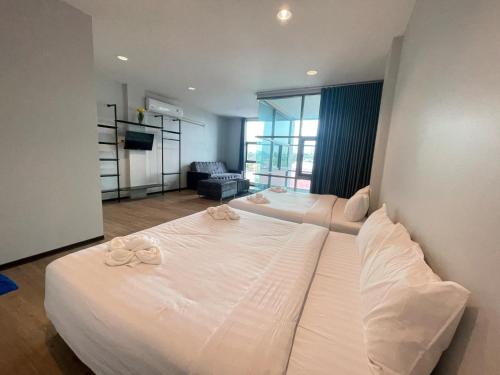 a bedroom with two beds and a living room at Lamoon Trang in Ban Phlu Phli