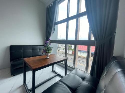 a living room with a couch and a table and a window at Lamoon Trang in Ban Phlu Phli