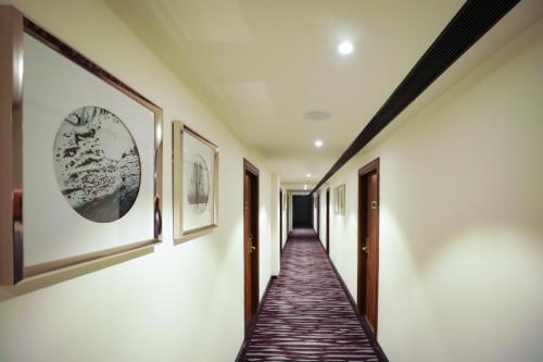 a corridor in a house with paintings on the walls at Regenta Suites Gurugram, Sector 49 Sohna Road in Gurgaon