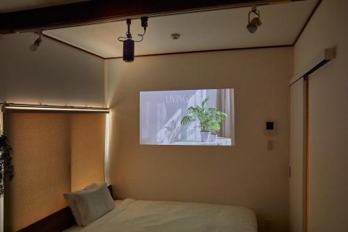 a bedroom with a bed with a potted plant on the wall at 2Rooms Haneda in Tokyo