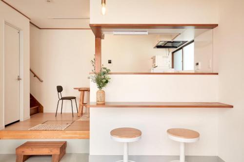 a kitchen with two stools and a mirror at 2Rooms Haneda in Tokyo