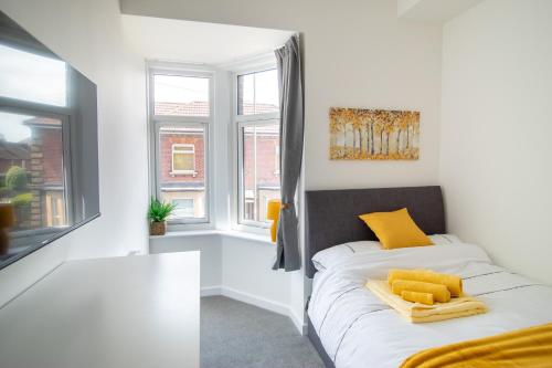 a bedroom with a bed with yellow pillows on it at 29 Twyford in Eastleigh