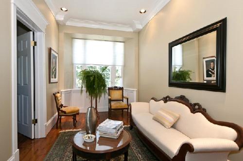 a living room with a white couch and a mirror at Clyde Hall Bed and Breakfast in Lanark