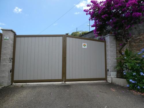a gate in a driveway with purple flowers at Maeva Sunset View in Punaauia