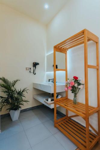 a bathroom with a sink and a vase of flowers at 云硕客栈 in Shangri-La