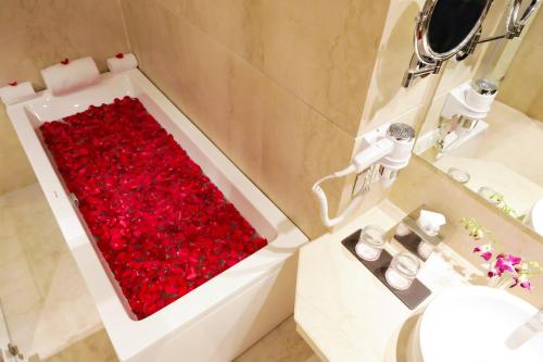 a bath tub filled with red roses in a bathroom at Regenta Suites Gurugram, Sector 49 Sohna Road in Gurgaon