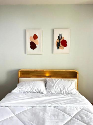 a bedroom with two pictures on the wall and a bed at Tranquil Urban Retreat at Cheangwattana in Pak Kret