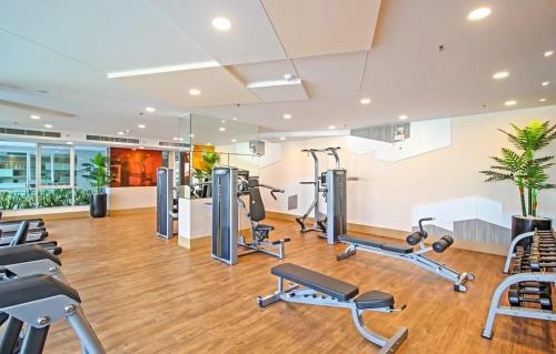 a gym with treadmills and exercise equipment in a building at Tranquil Urban Retreat at Cheangwattana in Pak Kret