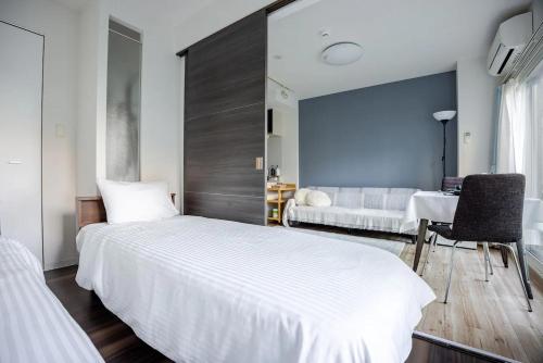 a bedroom with a large white bed and a table at Heart of Otaru, Сondo, Green Garden view in Otaru