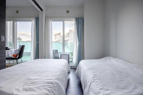 a bedroom with two beds and a view of the ocean at Heart of Otaru, Сondo, Green Garden view in Otaru