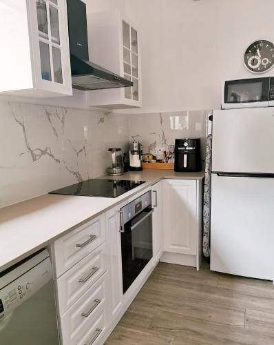 Una cocina con electrodomésticos blancos y un refrigerador blanco. en Oohlala - High ceiling Peaceful Relaxing Bushland view, en Mount Tamborine