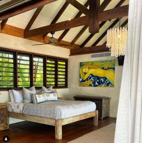 a bedroom with a bed and a painting on the wall at Spice At Oak Absolute Beachfront with Private Pool Near Port Douglas in Oak Beach