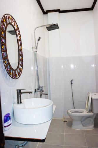 a bathroom with a sink and a toilet at Vang Vieng Sabai Sabai Hostel in Vang Vieng