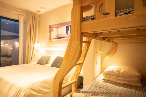 a bedroom with a bunk bed with white sheets at 北京怀柔方糖民宿 in Sanduhe