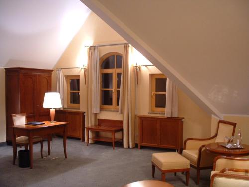 a room with a staircase with chairs and tables and windows at Altstadthotel Bräuwirt in Weiden