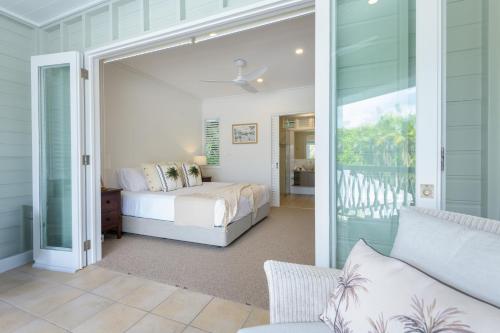 a bedroom with a bed and a sliding glass door at Villa 4 on Murphy in Port Douglas