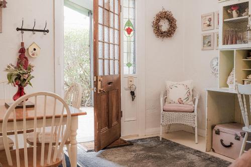 a room with a door and a table and chairs at Jasmine's Barossa Valley Cottage in Lyndoch
