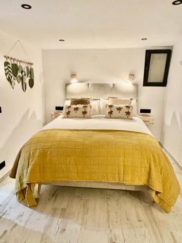 a bedroom with a large bed with a yellow bedspread at La Esquina 1B in Denia