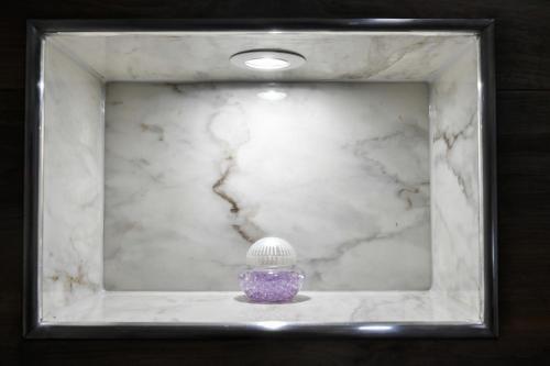 a purple vase in a frame with a marble wall at CASA BOX PREMIUM free garage in Maribor
