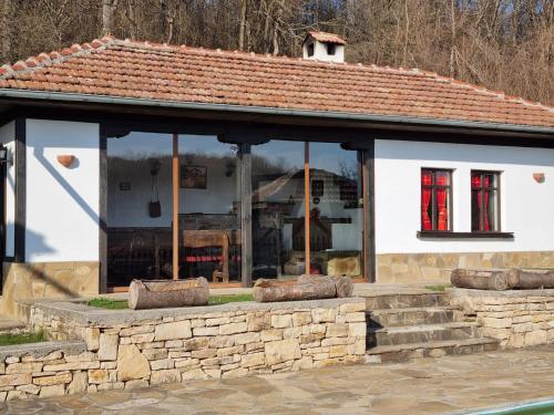 a building with windows and a stone wall at АРНАТА КЪЩА in Yakovtsi