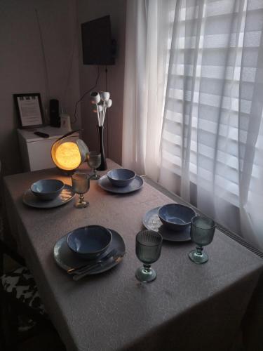 a table with blue plates and silverware on it at Vikendica Gaj in Gornji Milanovac