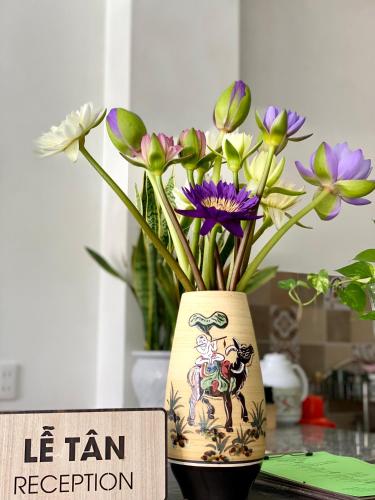a vase with flowers in it sitting on a table at Rice River Villa - Hoi An in Hoi An
