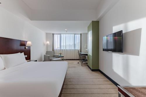 a hotel room with a bed and a flat screen tv at Holiday Inn Shanghai Vista by IHG - Easy access to travel spot city walk in Shanghai