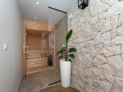 un bagno con doccia con parete in pietra di Villa Simpleza - Six Bedroom Villa with Private Pool and Jacuzzi a Klek