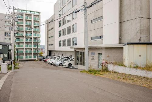 an empty parking lot with cars parked in front of buildings at Heart of Otaru, Сondo, Green Garden view in Otaru