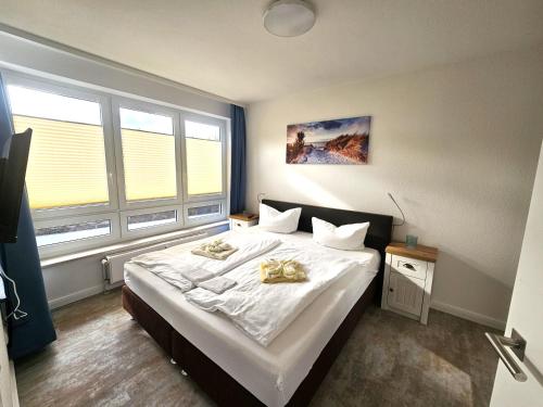 a bedroom with a large bed with two towels on it at Binzer Sterne 23 Typ B , ID BS123 in Binz
