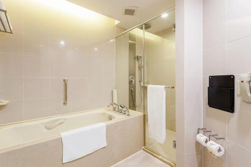 a white bathroom with a tub and a shower at Holiday Inn Shanghai Vista by IHG - Easy access to travel spot city walk in Shanghai