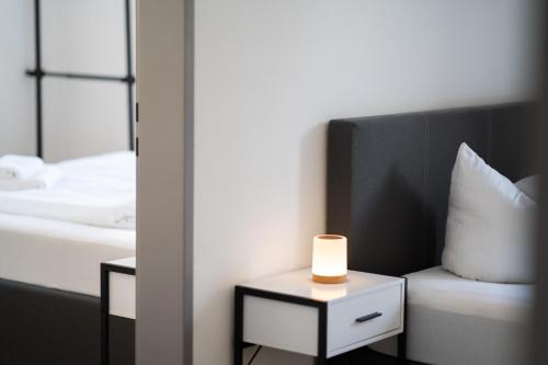 a bedroom with a bed and a lamp on a table at homy Lakeside Symphony in Bregenz am Bodensee in Bregenz