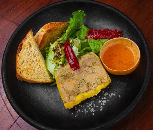 a black plate with a sandwich and a salad and sauce at Le Patio in Lomé