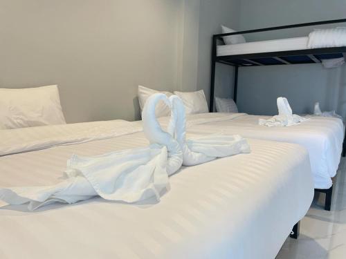 two swans are sitting on top of two beds at Lamoon Trang in Ban Phlu Phli