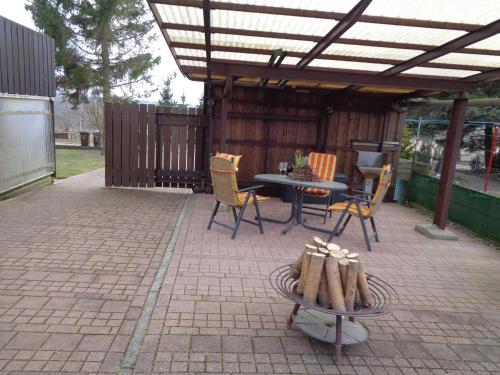 a patio with a table and chairs under a pergola at Ferienwohnung Am Recknitzhang in Carlewitz