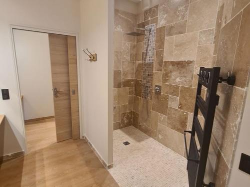a bathroom with a walk in shower next to a door at Chambre Amédée PMR chic avec Wi-Fi et petit déjeuner inclus - FR-1-590-479 in La Ferté-Saint-Aubin