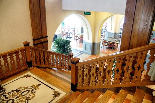 a staircase in a building with an arched entryway and aoyer with tables at Venus Hotel Tam Đảo in Tam Ðảo