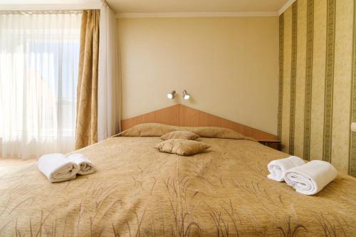 a bedroom with a large bed with towels on it at Noviz Hotel in Plovdiv