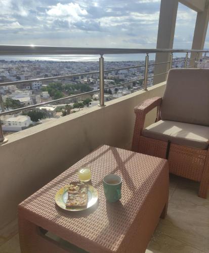a table with a plate of food on a balcony at haut standing vue exceptionnelle Bizerte Tunisie in Bizerte
