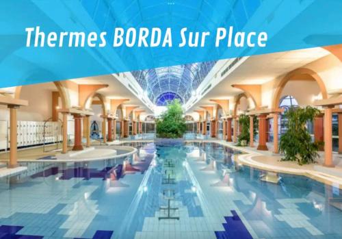 - une piscine dans un bâtiment avec les mots « border baroda super place » dans l'établissement Location pour curistes à Dax - résidence thermale Borda, à Dax